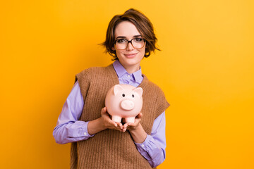 Photo of good mood positive girl dressed knitwear waistcoat in glasses hold money piggy box in arms...