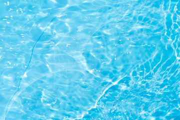Blue water with ripples on the surface. Defocus blurred transparent blue colored clear calm water surface texture with splashes and bubbles. Water waves with shining pattern texture background.