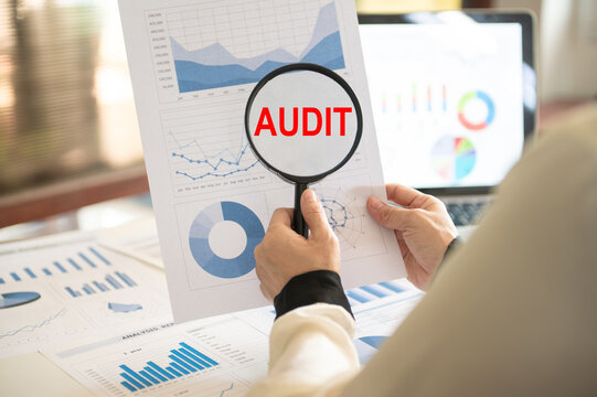 Magnifying glass with audit word. Auditing the reliability of financial report and internal control system audit and accounting.