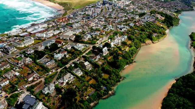 Aerial drone shot over the coastal town of Newquay in Cornwall, United Kingdom. High view of the Gannel river.