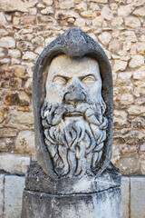 Ancient stone sculpture of a medieval warrior bust, emphasizing armor and heroic features in timeless style