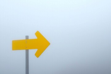 A bright yellow arrow icon cutting through a grey fog, symbolizing clarity in confusion. 
