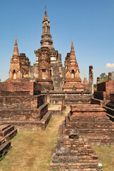 Obraz premium View onto the central structure of Wat Mahathat Temple with its many Chedis and Stupas, Historical Park, archaeological site, ancient ruins of Sukhothai, Thailand