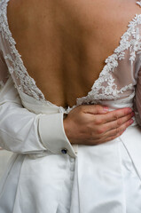 Groom embrace bride back detail