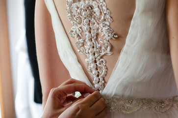 dressing up the wedding gown with pearl buttons