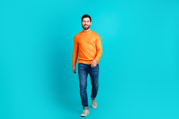 Photo of positive cheerful nice man wear trendy clothes walk isolated on aquamarine color background