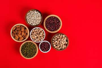 Mung beans, Red kidney beans, Chickpeas source and peeled barley in a basket wooden isolated on red background