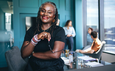 Portrait of a black woman standing in an office during a business meeting