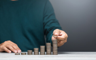 Man is stacking coins on a table, arranging them from smallest to largest. The image represents...