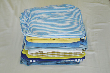 Stack of colourful clothes. Image of pile of clothing which can be used for upcycling, charity, ecological projects