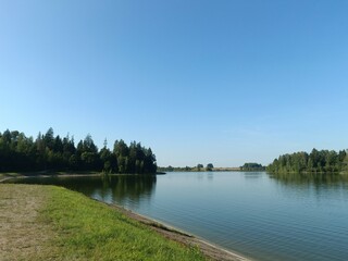 Bubiai lake during sunny day. Sunny day with white and gray clouds in blue sky. Wavy lake. Horizon over water. Bubiu ezeras.	