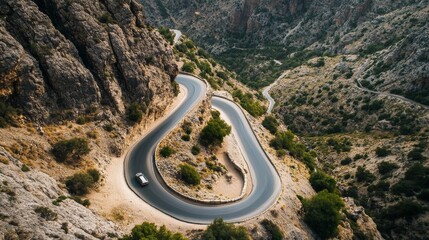 Aerial view of car and winding road in high mountain pass. Serpentine curvy road