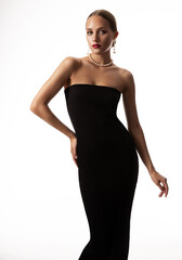 Fototapeta premium Fashion Woman in Little Black Dress. Elegant Lady in Cocktail Gown wearing Pearl Necklace Jewellery over isolated White. Beautiful Girl in Luxury Vintage Clothes