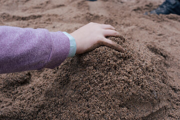 Child hand in sand