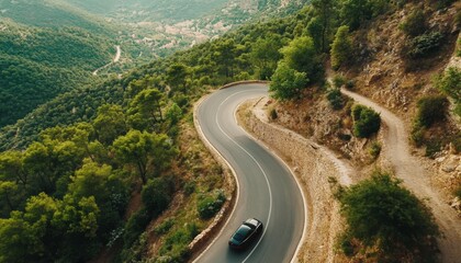 Fototapeta premium Car driving on a serpentine road. Curvy road surrounded by pine forest. Top view