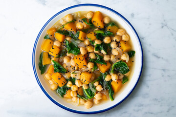 Chickpea stew with pumpkin and spinach. Top view table with Christmas decoration.