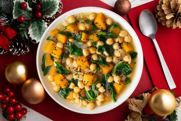Chickpea stew with pumpkin and spinach. Top view table with Christmas decoration.