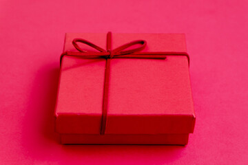 red gift box with ribbon on red table