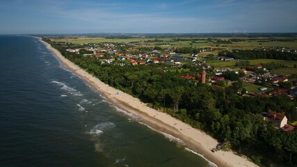 Gąski lighthouse and coastline captured by drone in a sunny summer panorama. © Grzegorz