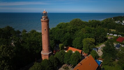 Drone view of Gąski lighthouse, Baltic coast, and village under a clear sky. © Grzegorz