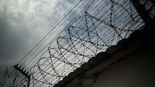 Barbed Wire Fence with Razor Wire. Prison wall