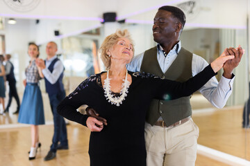 Man and mature woman learning to dance classical ballroom dance