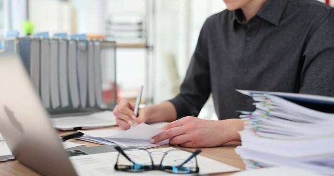 Manager reads financial documents with statistics makes corrections and compares data. Attentive woman making editorial changes to report in office