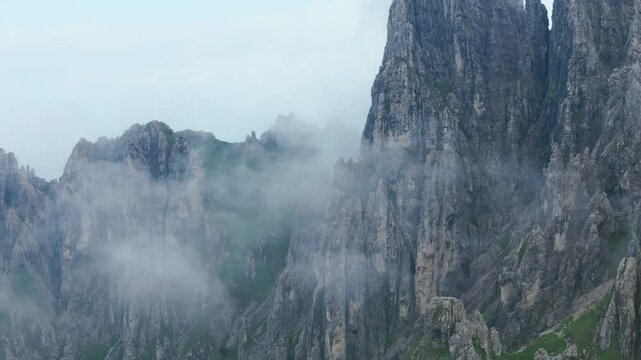 Lombardy, Italy - An Awe-Inspiring View of Jagged Peaks Veiled in Fog, Emerging From the Rugged Slopes of Grignetta - Aerial Drone Shot