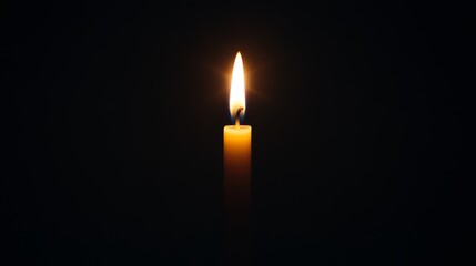 Fototapeta premium A serene image of a burning candle illuminating a dark space, creating a peaceful ambiance and warm atmosphere.