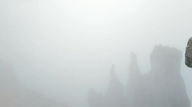 Lombardy, Italy - A Mesmerizing Scene of Grignetta's Jagged, Rugged Peaks Cloaked in Fog - Aerial Pullback Shot