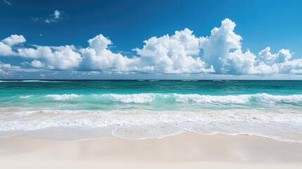 Obraz premium Beautiful beach with smooth white sand and gentle turquoise waves on a sunny day, framed by white clouds in the clear blue sky.