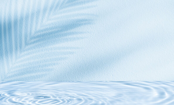 Water texture surface on blue wall background,Backdrop Summer nature light,palm leaves shadow on pool water ripple pattern for cosmetic product podium,Blue background for beautym,spa banner