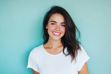 Fototapeta premium Smiling young woman against turquoise background