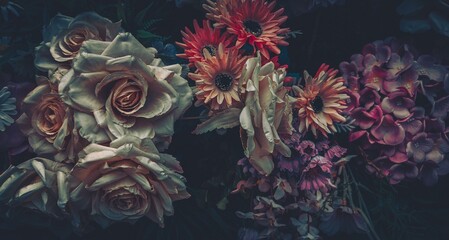 Vintage artificial flowers in a dark and moody setting.