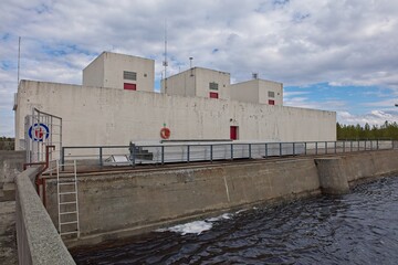 Skogfoss powerplant on Pasvik river in cloudy spring weather, Norway.