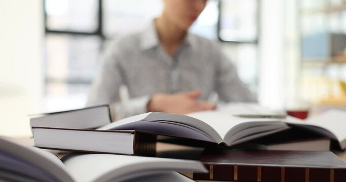 Student woman with many books preparing for exam. Studying law from scratch on your own