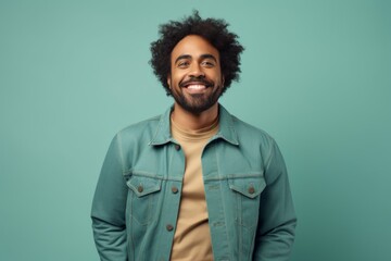 Obraz premium Portrait of a content afro-american man in his 40s sporting a rugged denim jacket over pastel teal background