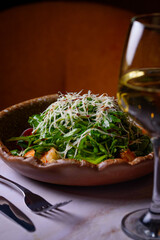 salad, arugula with shrimp, cherry tomatoes, cheese, glass of white wine