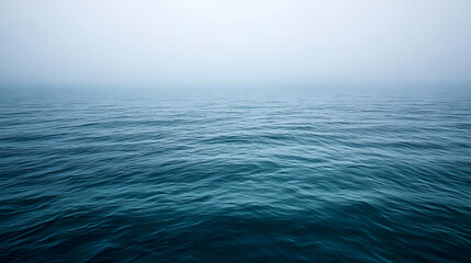 Obraz premium A Stunning Photo of the Ocean on a Foggy Day, Showing the Ripples in the Water Extending to the Horizon