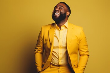 Obraz premium Portrait of a happy man in his 30s dressed in a stylish blazer on soft yellow background