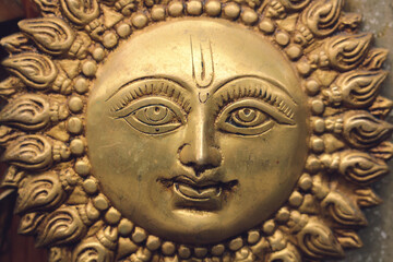 Bronze sun with a face in India. God Surya.