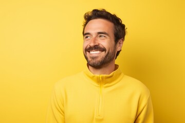 Obraz premium Portrait of a blissful man in his 30s wearing a thermal fleece pullover in front of soft yellow background