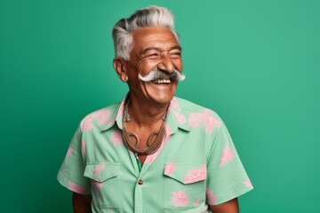 Fototapeta premium Portrait of a joyful indian man in his 80s sporting a vintage band t-shirt in soft green background