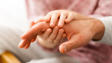 Kids love. Close up of little girl holding father palm with both hands