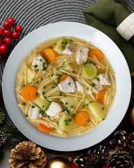 Fish, noodle and vegetable soup. Top view table with Christmas decoration.