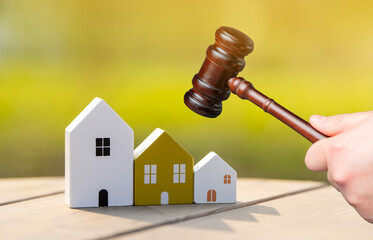 Wooden houses and judge's hammer. Real estate court decisions. Property inheritance litigation. Establishment of ownership.