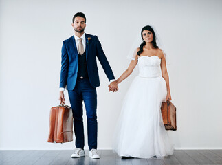 Groom, bride and holding hands for wedding, relationship and honeymoon with suitcase and portrait....
