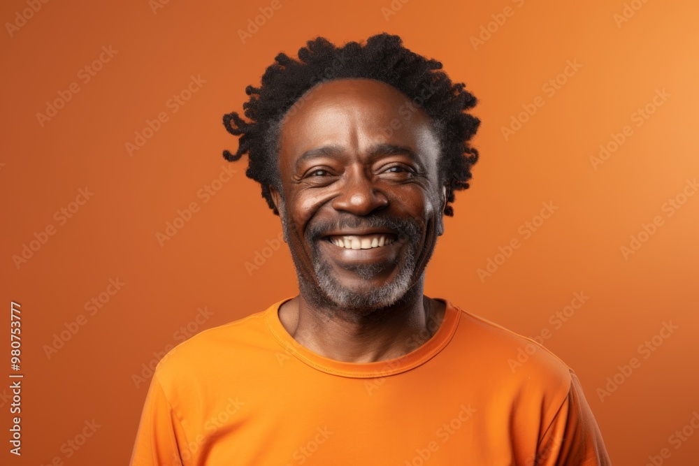 Canvas Prints Portrait of a smiling afro-american man in his 50s showing off a lightweight base layer over soft orange background