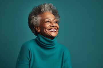 Fototapeta premium Portrait of a blissful afro-american elderly woman in her 90s wearing a classic turtleneck sweater over soft teal background