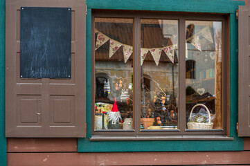 Charming shop window decorated with festive items in a quaint village during autumn